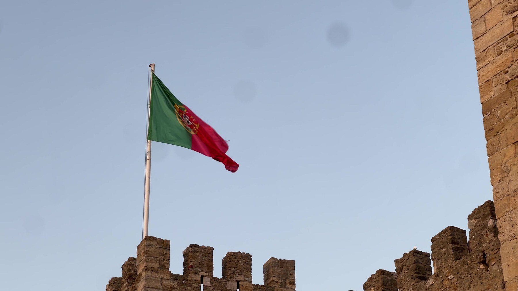 A bandeira de Portugal tremulando sobre a muralha