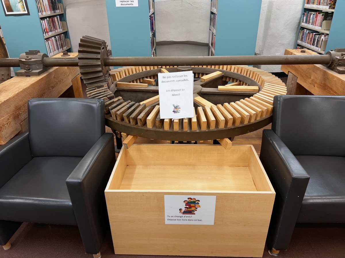 図書館の机のあいだに置かれた製材所の歯車